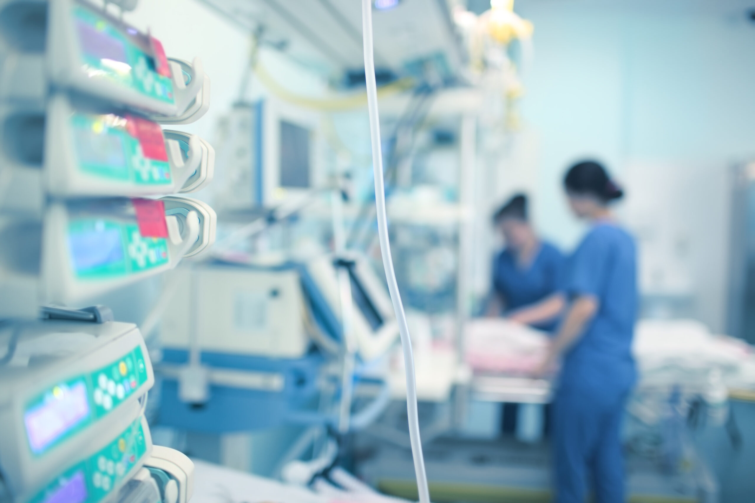 Zwei Krankenpflegerinnen versorgen einen Patienten auf der Intensivstation.