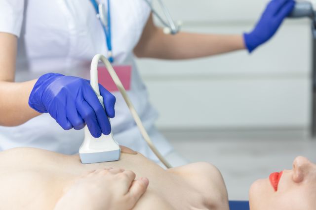 Eine Ärztin untersucht mittels Ultraschall die Brüste einer jungen Patientin. Arztpraxis.