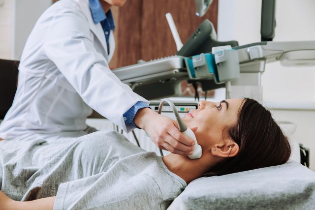Das Bild zeigt eine Frau, deren Lymphknoten per Sonographie untersucht werden.