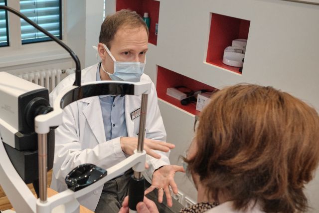 Dr. Boris Stanzel mit Patientin bei einer Augenuntersuchung