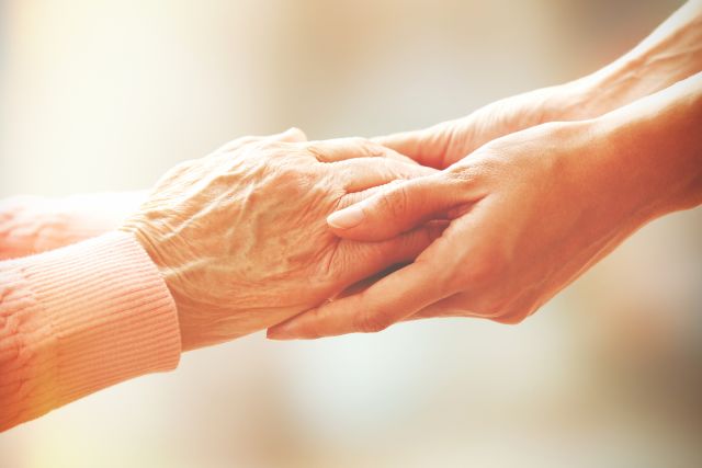 Zwei Hände, die symbolisch Fürsorge und Unterstützung in der Geriatrie darstellen, passend zum Thema pAVK.