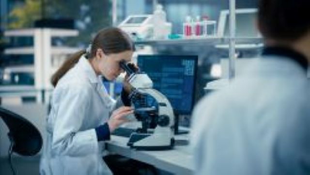 Wissenschaftlerin untersucht Proben unter dem Mikroskop in einem modernen Labor
