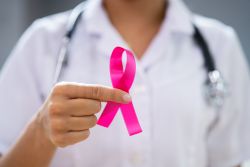 Ärztin hält eine rosa Schleife als Symbol für Brustkrebsbewusstsein