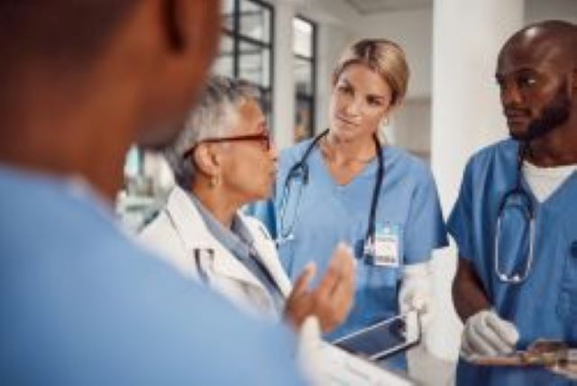 „Medizinisches Team in blauen Kitteln bei einer Besprechung in einem Krankenhaus“