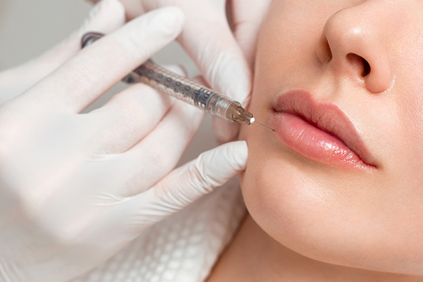 Nahaufnahme einer Faltenunterspritzung mit Botox-Injektion durch eine Fachkraft.