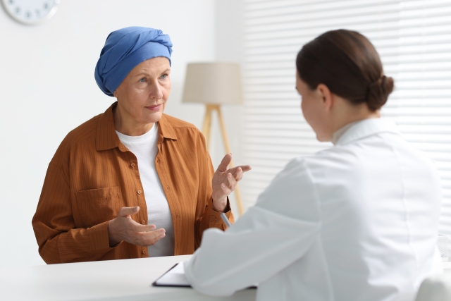 Ärztin im Gespräch mit einer Patientin über Nebenwirkungsmanagement bei Krebstherapie.