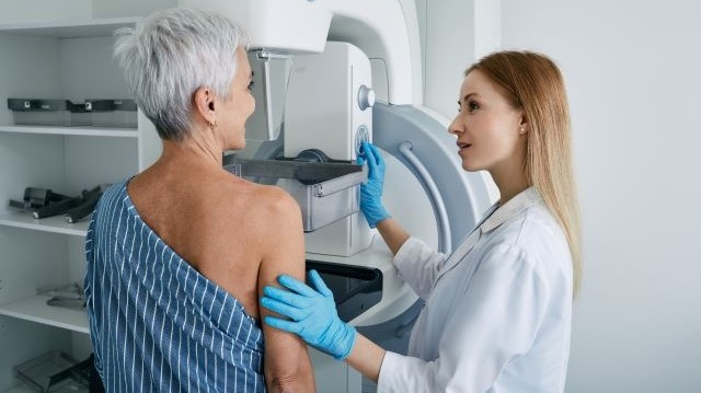 Ältere Frau bei einer Mammographie im Krankenhaus mit medizinischem Fachpersonal