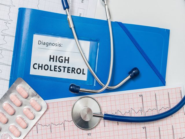 Diagnose hoher Cholesterinspiegel mit Medikamenten, Stethoskop und EKG-Diagramm.