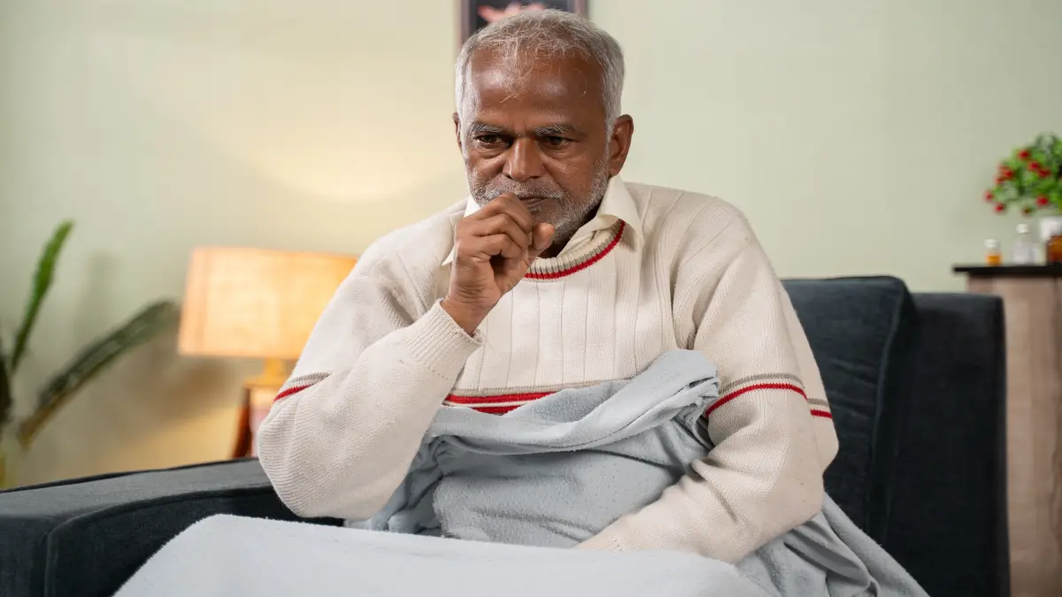 Sick old man woke up in the middle of night while sleeping due to fever and cough.