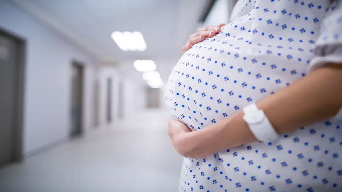 Schwangere Frau im Krankenhausflur.