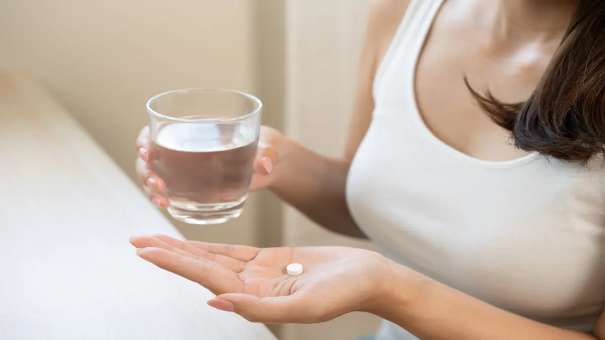 Junge Frau mit Antibiotika in der Hand