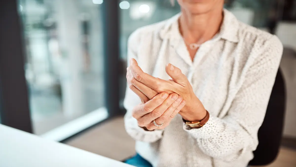 Frau mit Handgelenksschmerzen im Büro