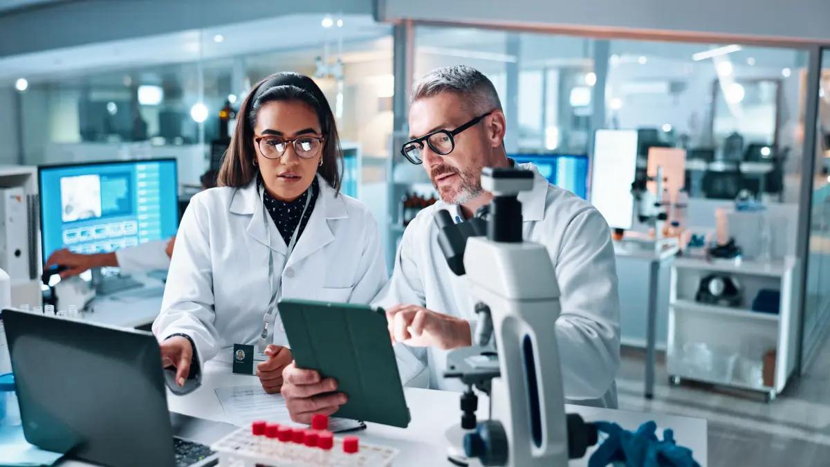 Forschende im Labor arbeiten an präzisen Therapien gegen Tumorresistenz mit Ionenstrahlen und CAR-T-Zellen.