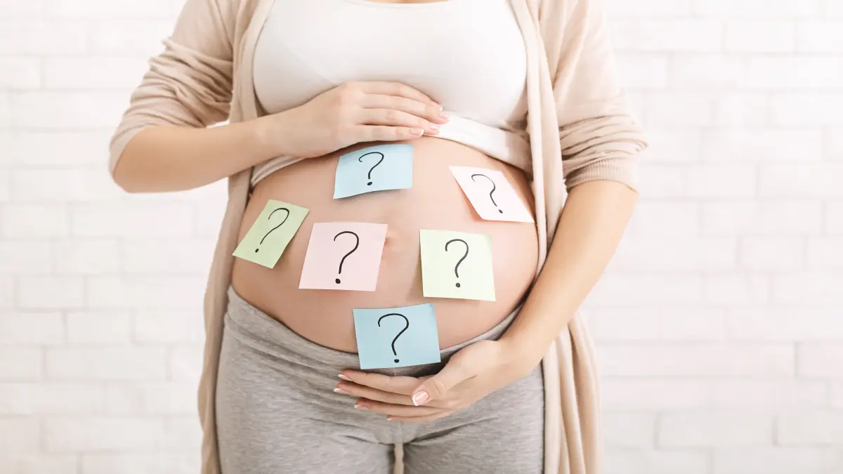 Schwangere Frau mit Fragezeichen auf dem Bauch, symbolisiert Unsicherheiten bei Kinderwunsch und Schwangerschaft von Epilepsiepatientinnen.