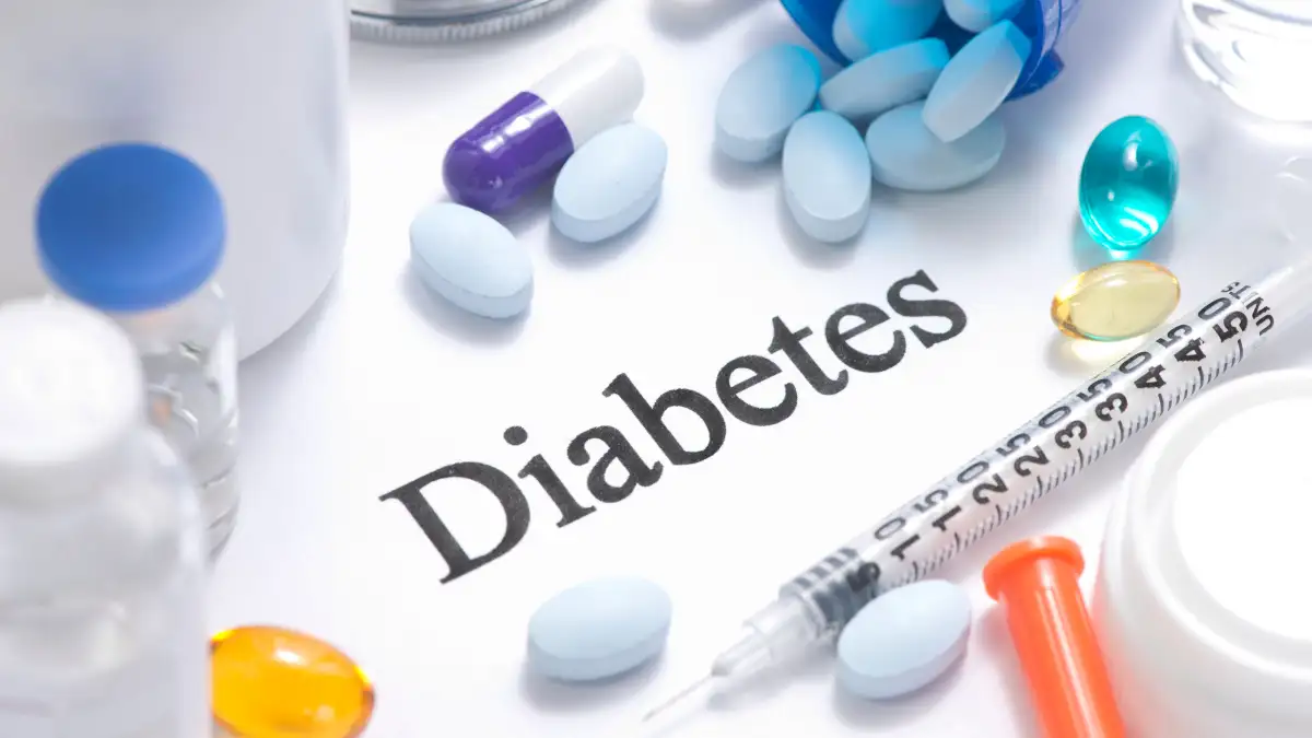 Der Schriftzug Diabetes auf weißem Grund ist umringt von verschiedenen bunten Pillen und Spitzen.
