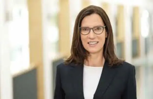 Portrait von Dr. Sibylle Steiner in einem dunklen Blazer vor einem modernen Bürohintergrund.
