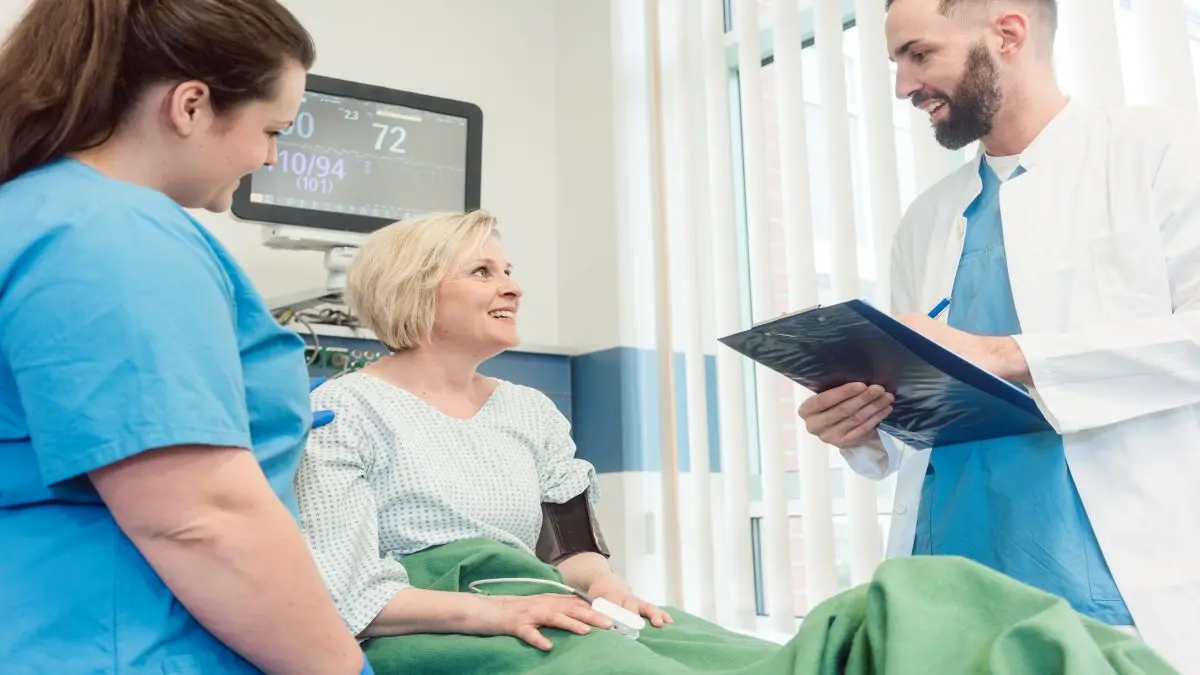 Patientin mit Herzinsuffizienz im Krankenhausbett mit Infusion in hellem, modernen Krankenzimmer