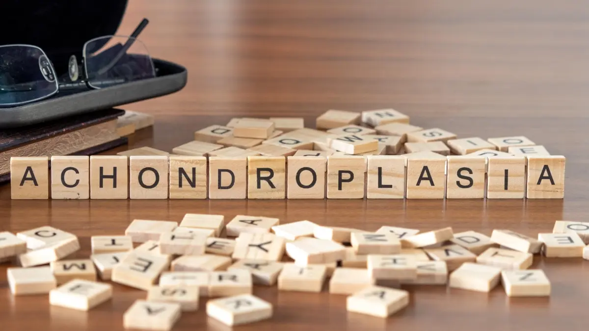 Achondroplasie – Wort dargestellt durch Holzbuchstaben auf einem Holztisch
