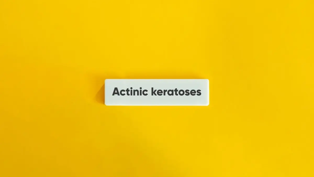 Weißer Schriftzug "Actinic keratoses" auf gelbem Hintergrund.