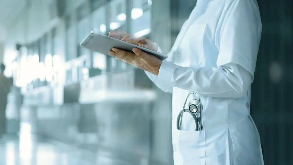 Arzt in moderner Klinik nutzt Tablet – Digitalisierung im Gesundheitswesen