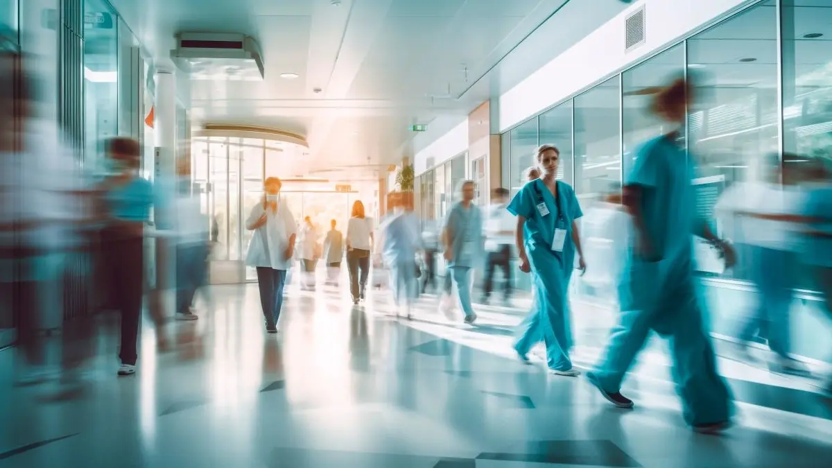 Dynamische Szene in einem Krankenhausflur mit medizinischem Personal und Patienten in Bewegung.