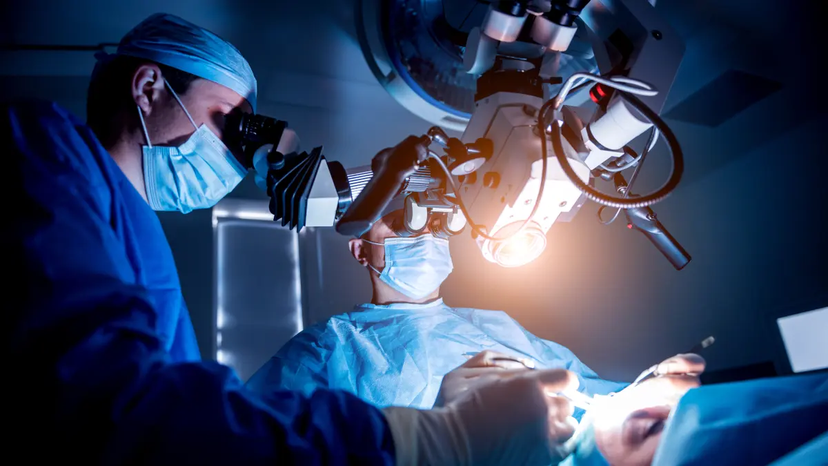 Neurochirurgen führen eine Hirntumor-Operation unter einem hochmodernen Operationsmikroskop durch