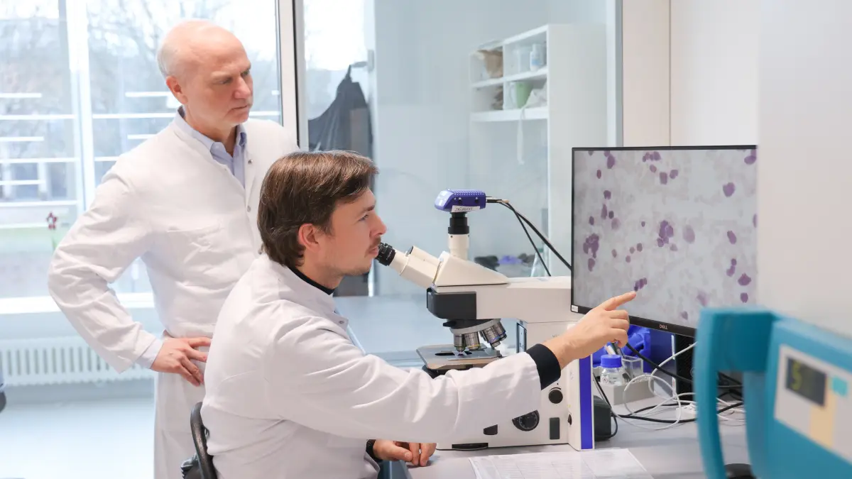 Wissenschaftler im Labor analysieren Zellproben unter dem Mikroskop zur Erforschung neuer Therapien für T-Zell-Leukämie.