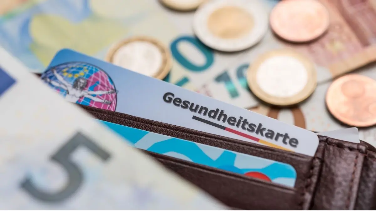 Gesundheitskarte in Geldbörse mit Euro-Münzen und -Scheinen – Symbol für Krankenversicherung und Kosten