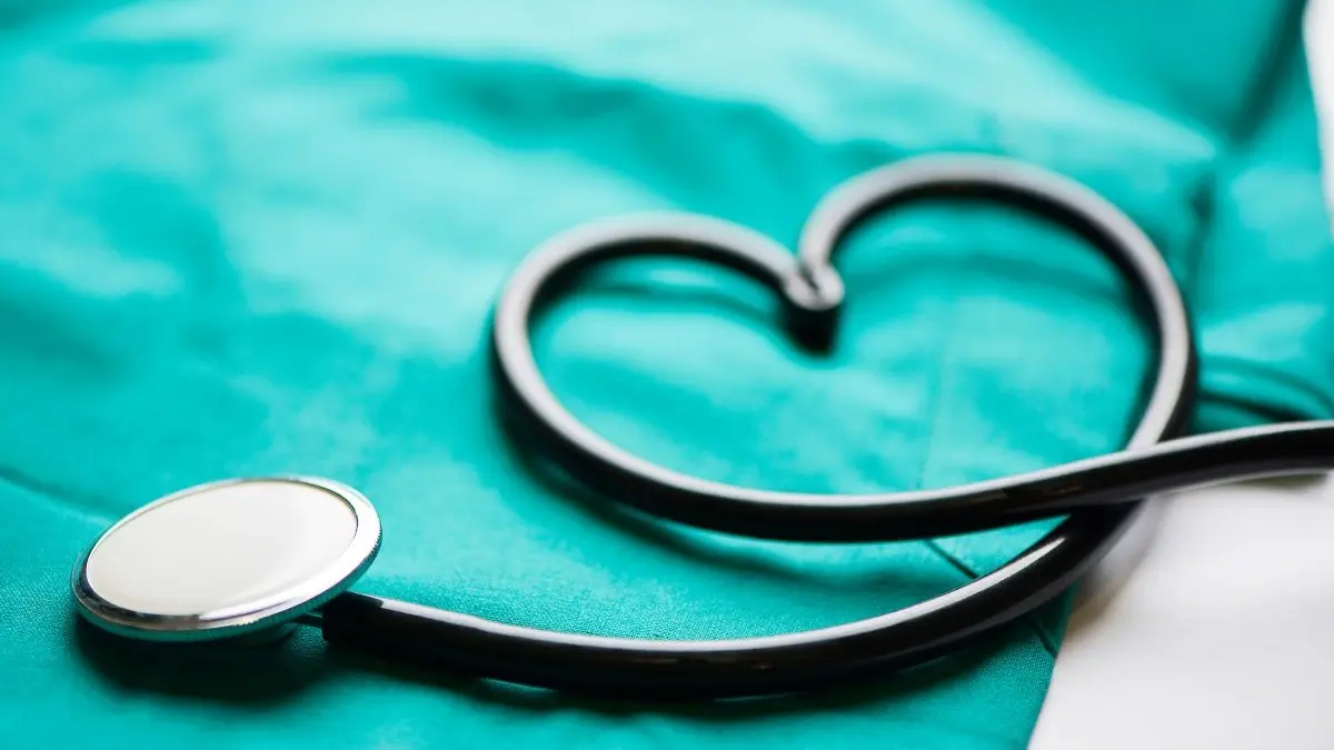 Stethoskop in Herzform auf tuerkisfarbenem OP-Tuch als Symbol fuer Praxisrelevanz und Effizienz in der Medizin