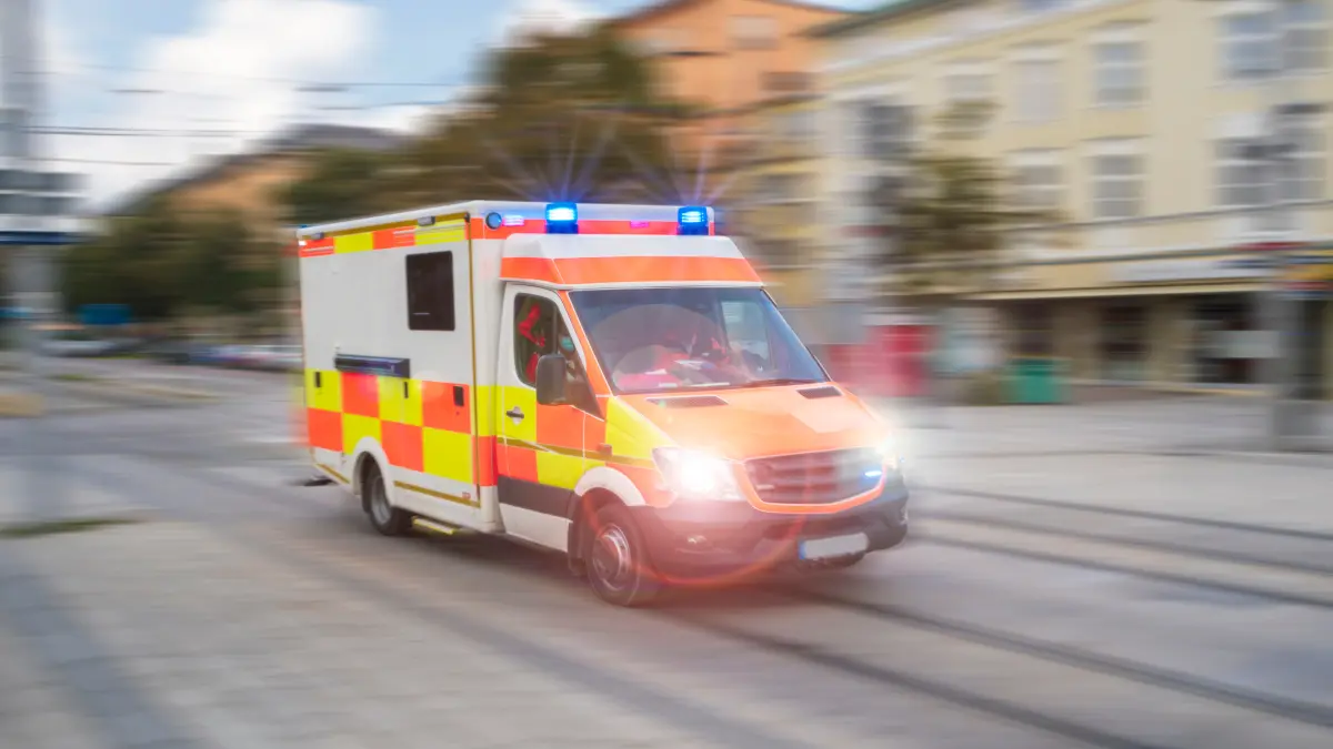 Rettungswagen im Einsatz fährt mit Blaulicht durch die Innenstadt