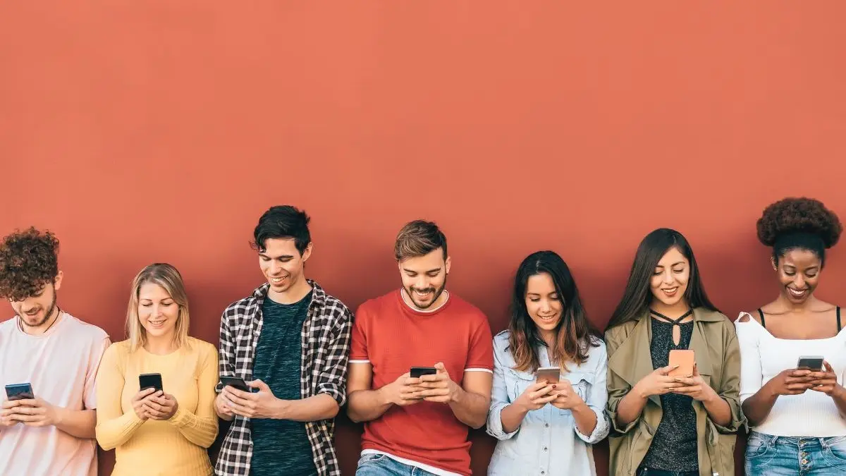Gruppe junger Menschen schaut auf Smartphones als Symbol fuer Social Media Kurzvideos mit oft mangelhaften medizinischen Informationen
