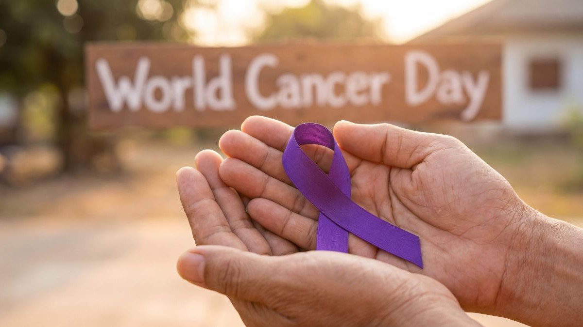 Lila Schleife für Weltkrebstag Awareness in Händen vor „World Cancer Day“-Schild.