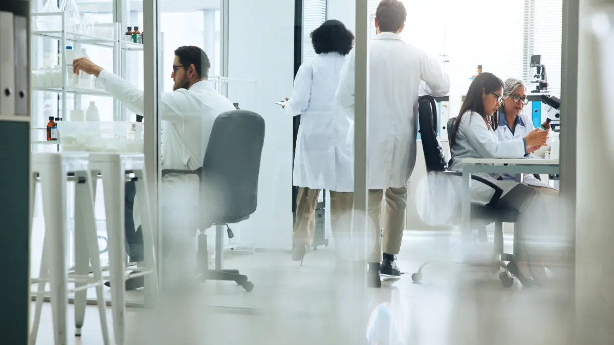 Forschungsteam in weißen Kitteln bei der Laborarbeit – Symbolbild für die Entwicklung der steuerbaren CAR-T-Zelltherapie