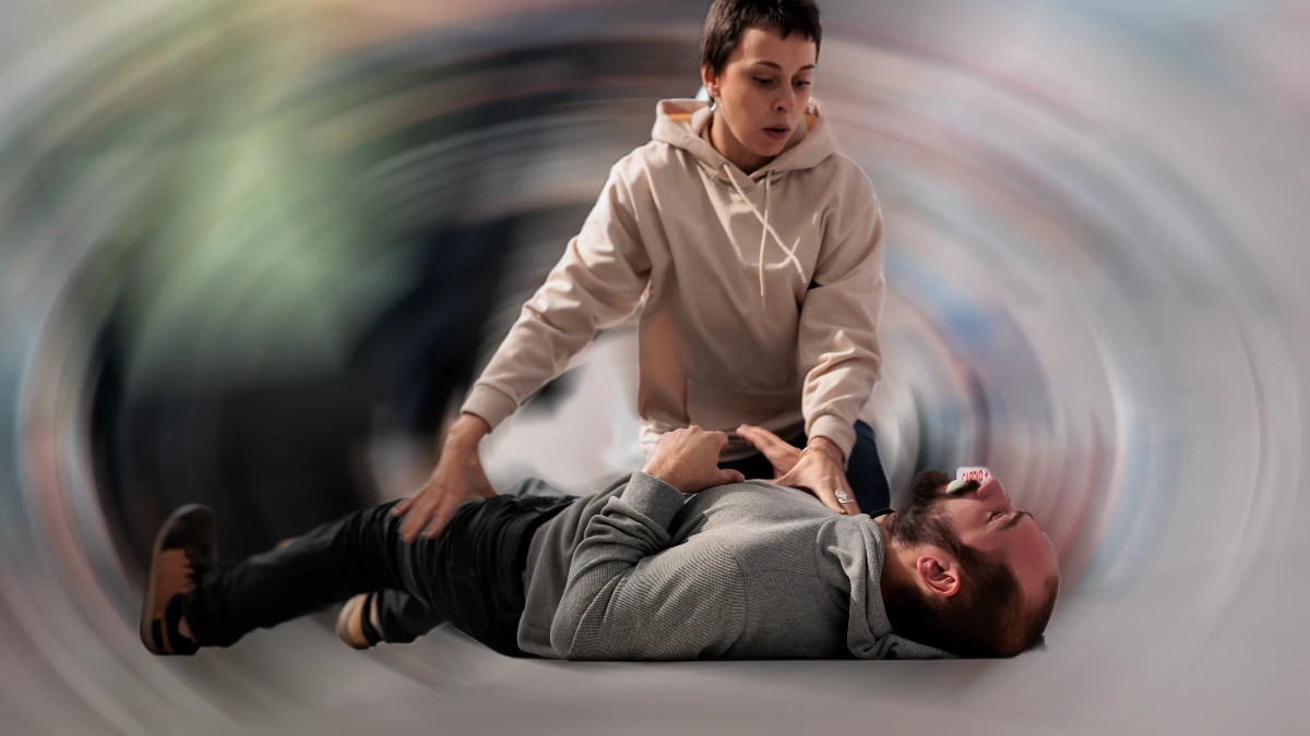 Bewusstloser Mann liegt auf dem Boden einer Apotheke, eine Frau leistet Erste Hilfe bei epileptischem Anfall