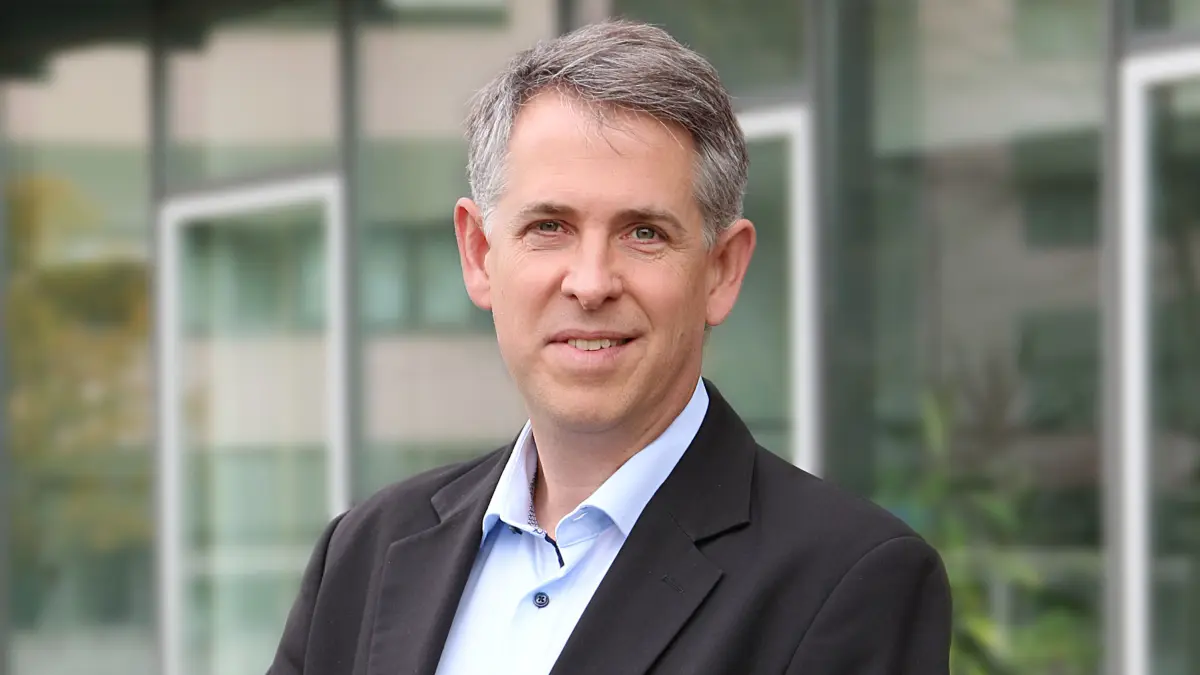 Portrait Stefan Pfister vor Klinikgebäude (verpixelt) – Direktor des Hopp Kindertumorzentrums Heidelberg, ausgezeichnet mit dem Ammann Preis für Kinderkrebsforschung