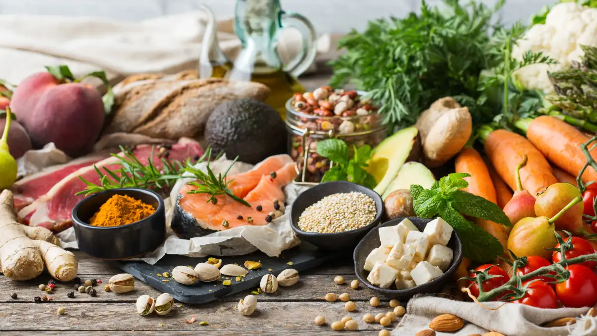 Eine Ansammlung gesunder Lebensmittel mit Fisch, Früchten, Nüssen und Gemüse.
