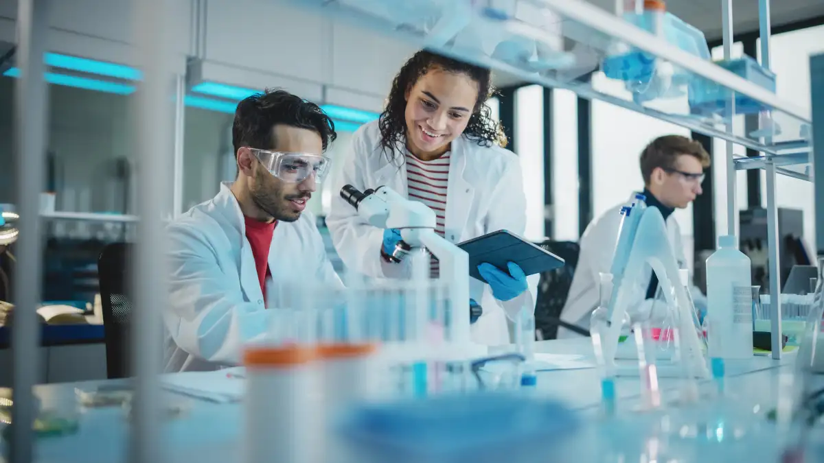 Labormitarbeitende stehen in einem wissenschaftlichen Labor.