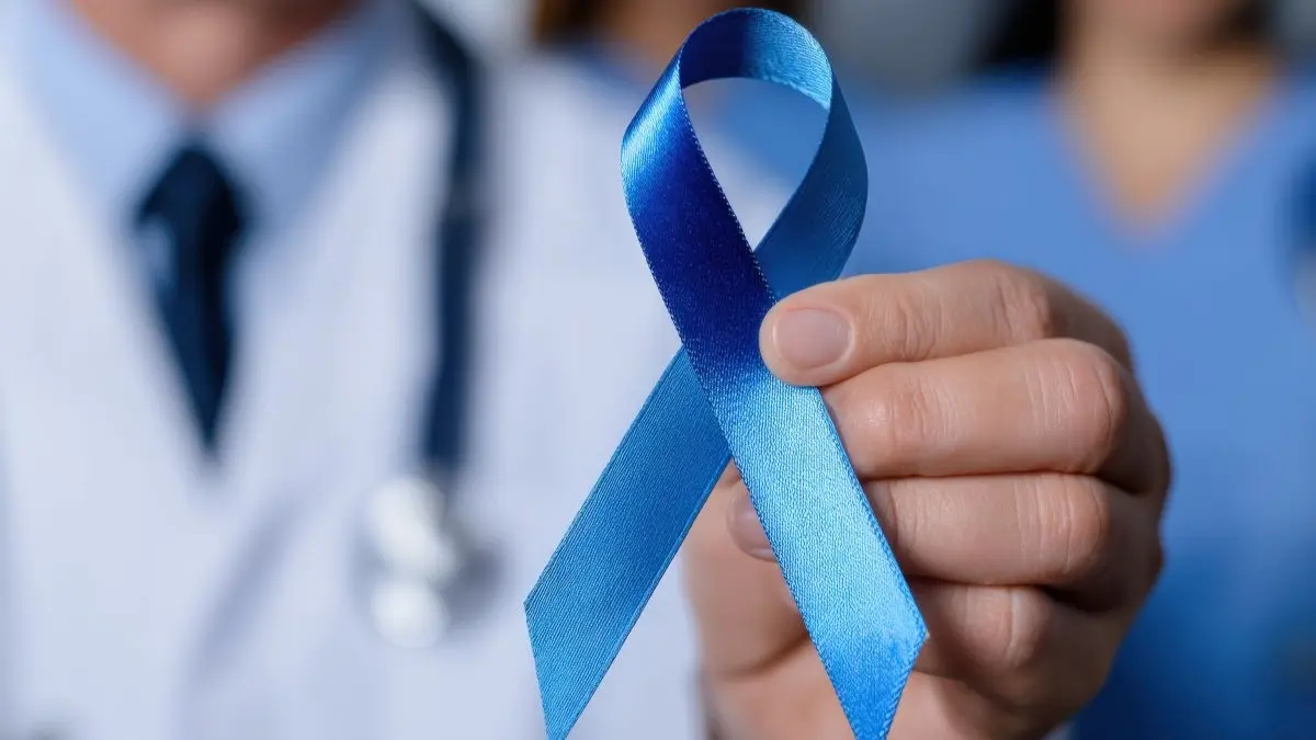 Hand haelt eine blaue Bewusstseinsschleife als Symbol fuer urogenitale Tumoren und aktuelle Therapieansaetze