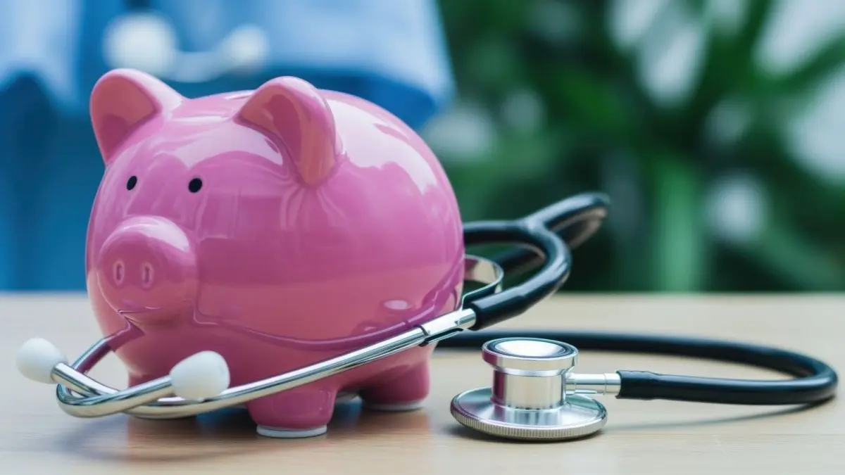 Rosa Sparschwein mit Stethoskop als Symbol fuer Sparmassnahmen und finanzielle Entscheidungen im Gesundheitssystem