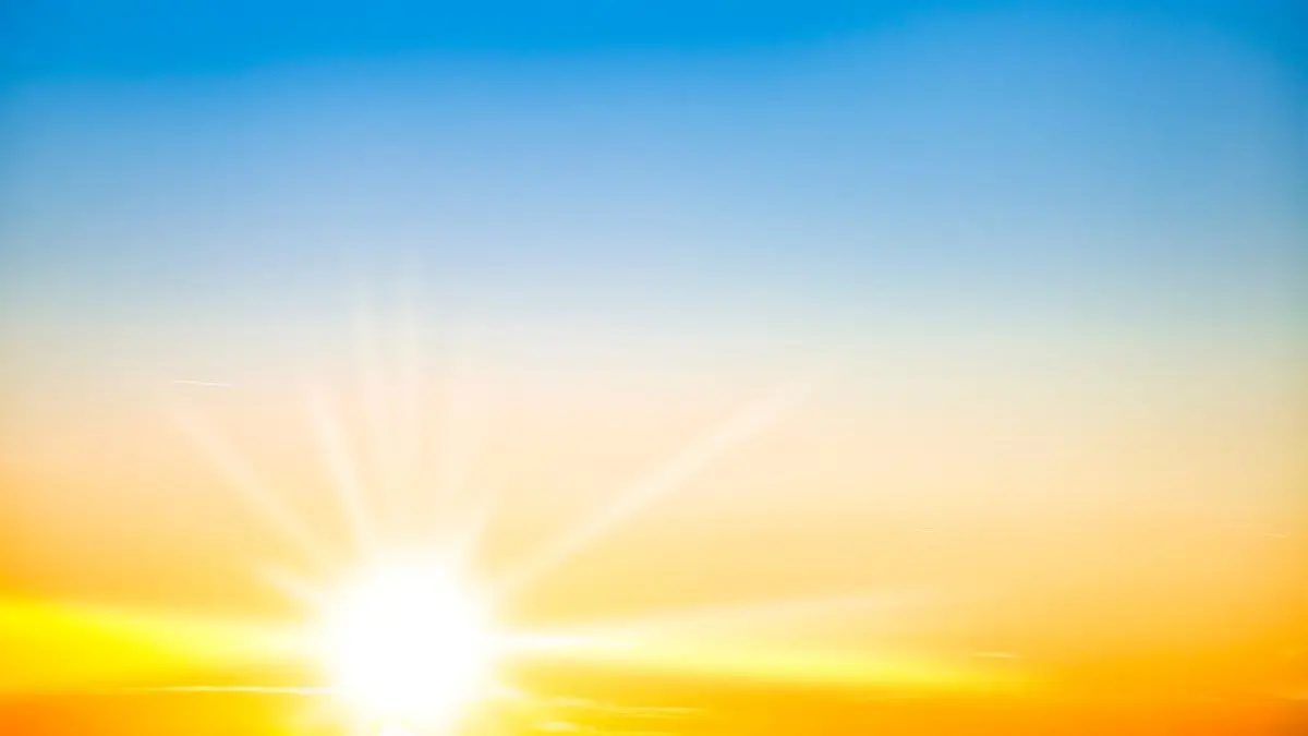 Strahlende Sonne am blauen Himmel als Warnung, dass Medikamente die Haut fuer UV Strahlung sensibilisieren koennen