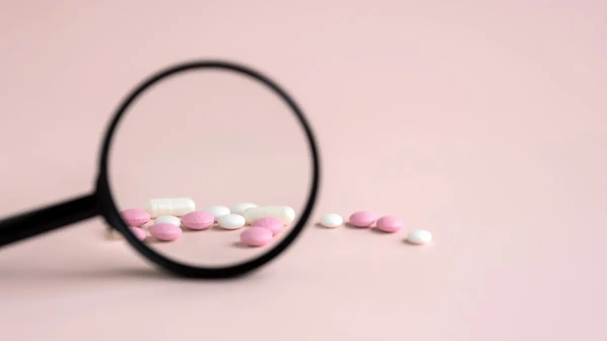 Tabletten unter einer Lupe zum Thema Biofaktoren