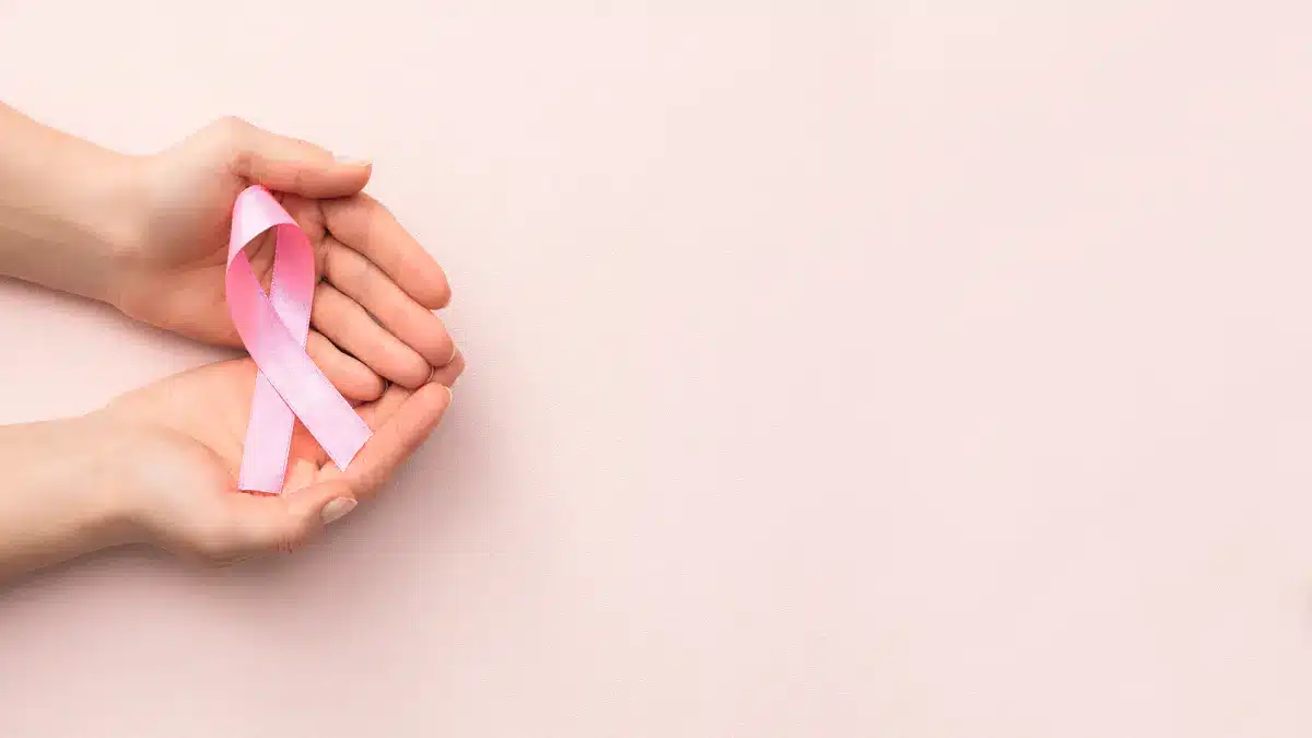 Haende halten eine pinke Schleife als Symbol fuer Brustgesundheit und Brustkrebsaufklaerung