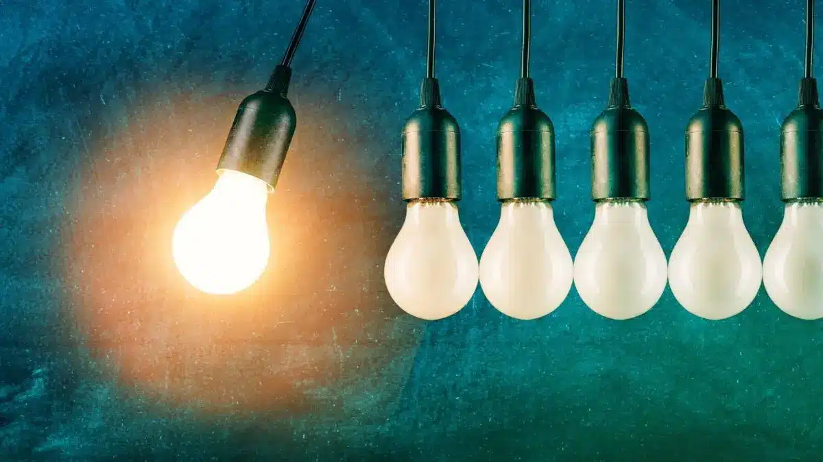 Mehrere haengende Gluehbirnen, eine leuchtet hell und steht symbolisch fuer starke Impulse in Praxis und Klinik