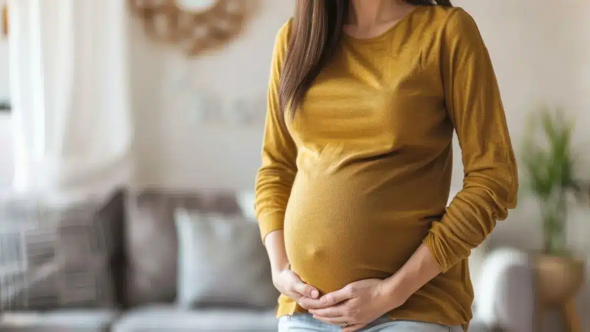 Schwangere Frau haelt sich den Babybauch als Symbol fuer Fruehwarnzeichen fuer spontane Fruehgeburten im Immunsystem