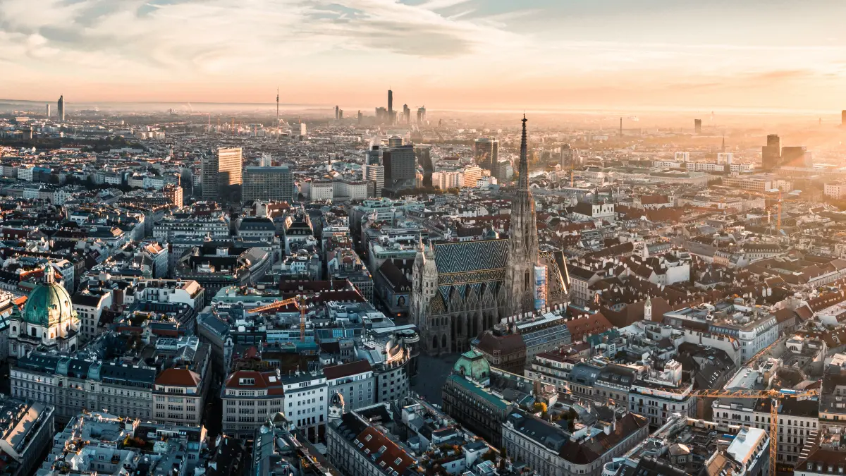 Weitwinkel-Luftaufnahme von Wien bei Sonnenaufgang mit Stephansdom und Skyline als Symbolbild fuer die Jahrestagung Haematologie und Onkologie 2026