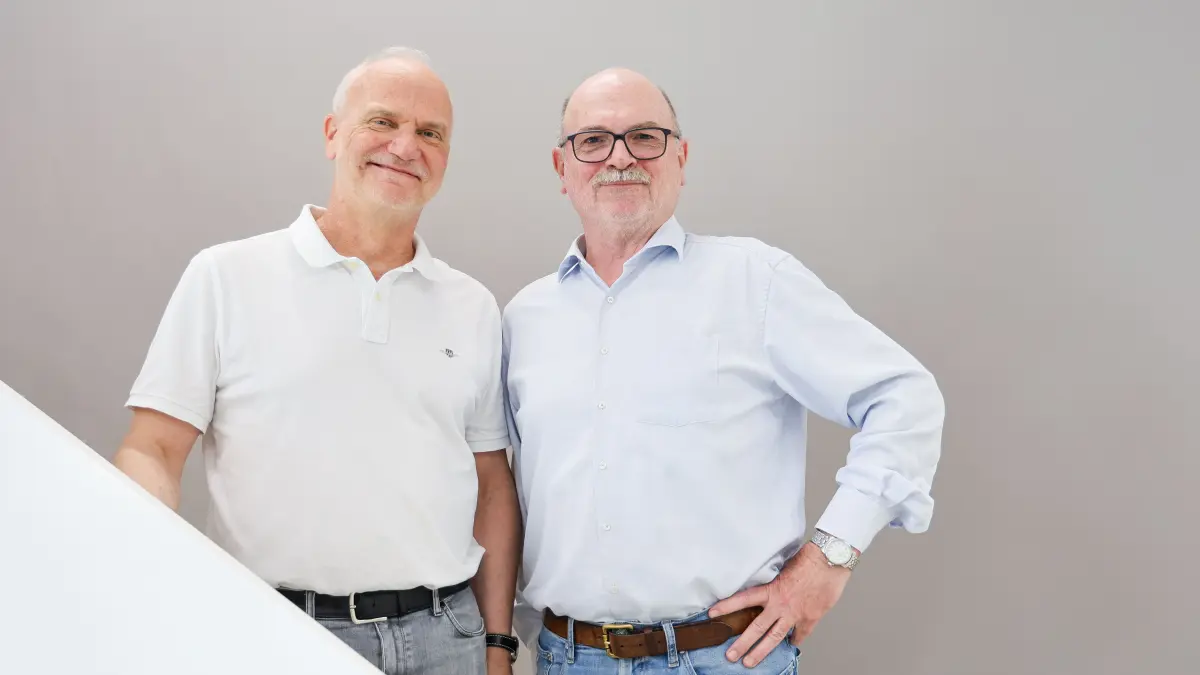 Zwei aeltere Maenner in hellen Hemden stehen nebeneinander und laecheln in die Kamera, Symbolbild fuer die Studienleitung einer Immuntherapie-Studie bei kindlicher akuter lymphatischer Leukaemie