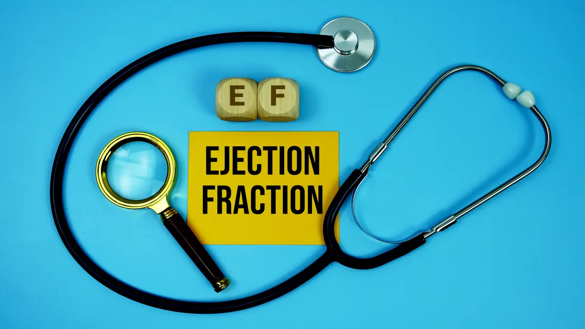 Stethoskop und Lupe neben Holzwürfeln mit „EF“ und Karte „Ejection Fraction“ auf blauem Grund