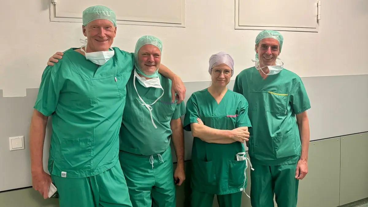 Vier Mitglieder des ärztlichen OP-Teams stehen in grüner OP-Kleidung nebeneinander.