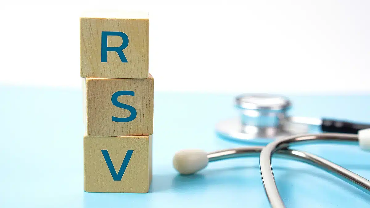 Holzwürfel mit den Buchstaben „RSV“ und einem Stethoskop im Hintergrund